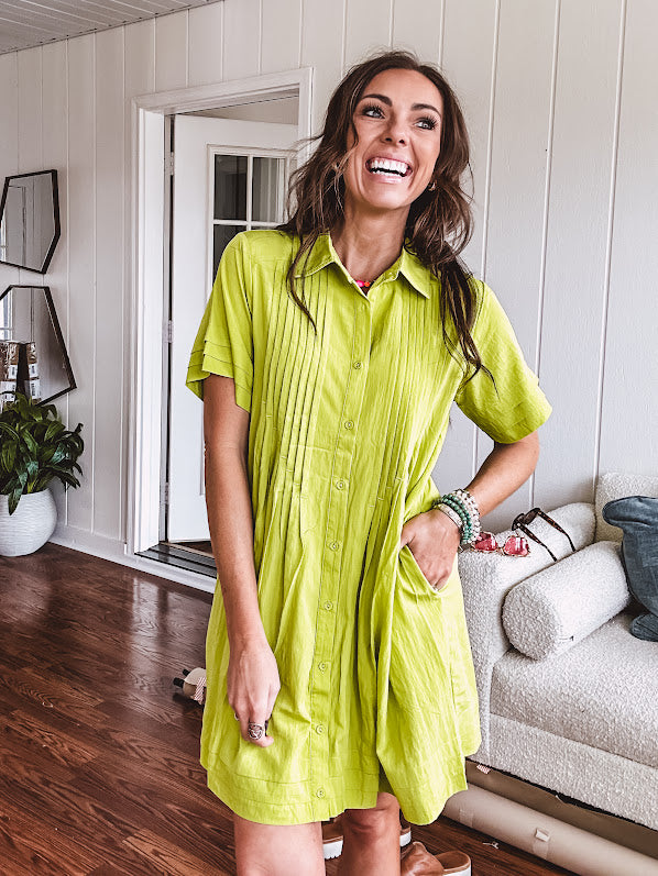 Chartreuse short sleeved button down dress, mini length with pintuck detail in front and pockets.