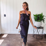 Fully lined black jumpsuit with sleeveless, ruffled bodice, smocked back, wide leg design and pockets at the pleated front.
