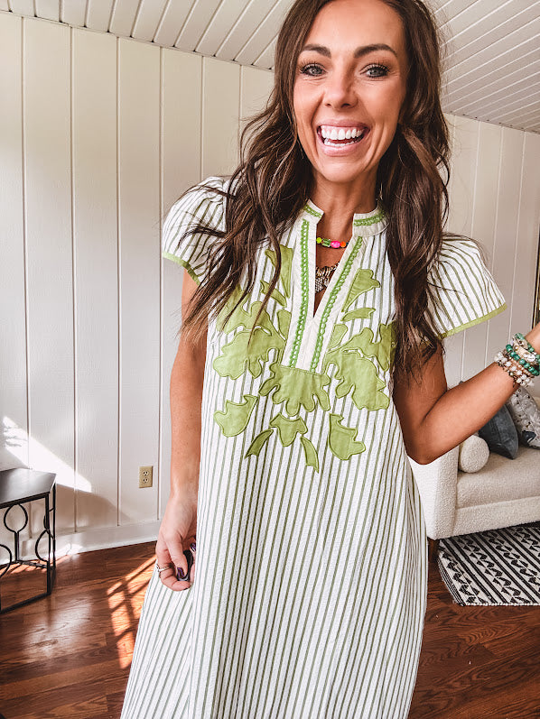 Sage and white striped midi length dress with short sleeves, mock collar, V neck and sage floral embroidery at the yoke and sage trim with side slits.
