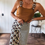 Wide leg lightweight button and zipper closure pants with elastic back waist featuring cream and black stripes down one leg and moon and star checkerboard in black, cream and mustard on the other leg.