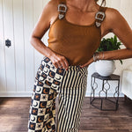 Camel colored ribbed textured bodysuit with snap closure and silver western buckle adjustable shoulder straps with square neckline.