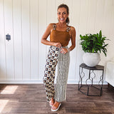 Wide leg lightweight button and zipper closure pants with elastic back waist featuring cream and black stripes down one leg and moon and star checkerboard in black, cream and mustard on the other leg.