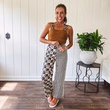 Wide leg lightweight button and zipper closure pants with elastic back waist featuring cream and black stripes down one leg and moon and star checkerboard in black, cream and mustard on the other leg.