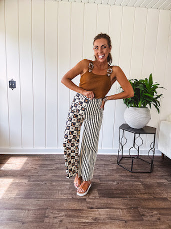 Wide leg lightweight button and zipper closure pants with elastic back waist featuring cream and black stripes down one leg and moon and star checkerboard in black, cream and mustard on the other leg.