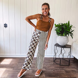 Wide leg lightweight button and zipper closure pants with elastic back waist featuring cream and black stripes down one leg and moon and star checkerboard in black, cream and mustard on the other leg.