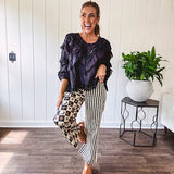 Wide leg lightweight button and zipper closure pants with elastic back waist featuring cream and black stripes down one leg and moon and star checkerboard in black, cream and mustard on the other leg.