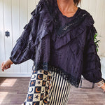 Black long sleeved blouse with lace and eyelet ruffle detail throughout.