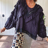 Black long sleeved blouse with lace and eyelet ruffle detail throughout.