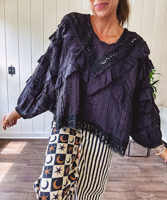 Black long sleeved blouse with lace and eyelet ruffle detail throughout.