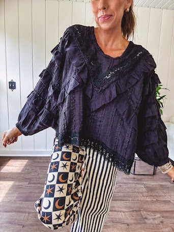 Black long sleeved blouse with lace and eyelet ruffle detail throughout.