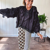 Black long sleeved blouse with lace and eyelet ruffle detail throughout.