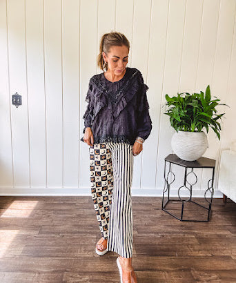 Black long sleeved blouse with lace and eyelet ruffle detail throughout.