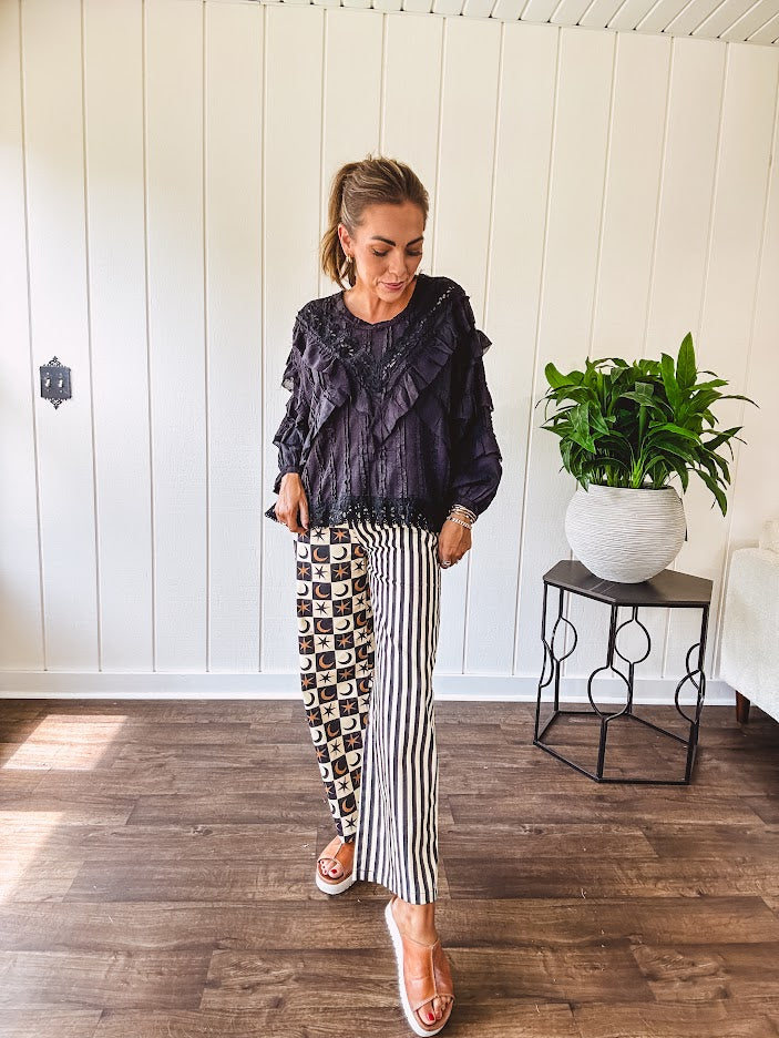 Black long sleeved blouse with lace and eyelet ruffle detail throughout.