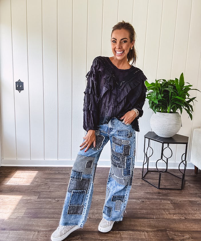 Medium wash denim wide leg pants with washed black, black and white stripe and denim patchwork detail throughout.