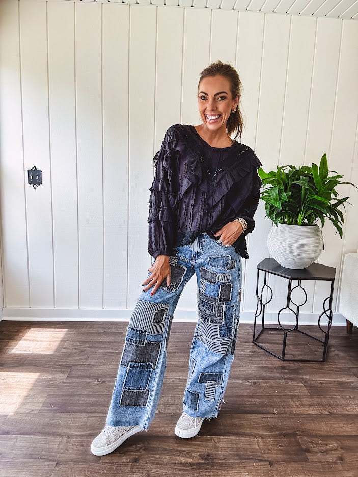 Medium wash denim wide leg pants with washed black, black and white stripe and denim patchwork detail throughout.