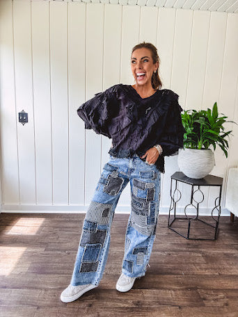 Medium wash denim wide leg pants with washed black, black and white stripe and denim patchwork detail throughout.
