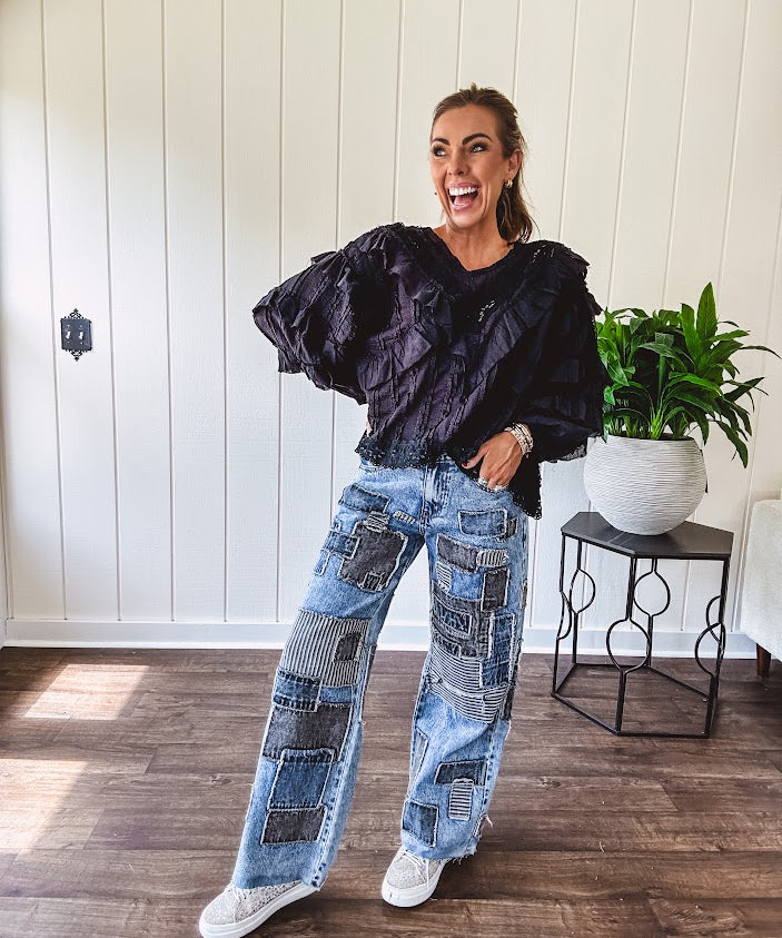 Medium wash denim wide leg pants with washed black, black and white stripe and denim patchwork detail throughout.