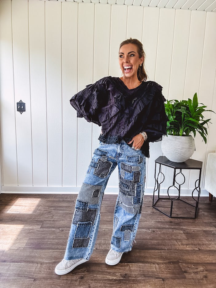 Medium wash denim wide leg pants with washed black, black and white stripe and denim patchwork detail throughout.
