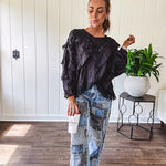 Medium wash denim wide leg pants with washed black, black and white stripe and denim patchwork detail throughout.
