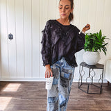Medium wash denim wide leg pants with washed black, black and white stripe and denim patchwork detail throughout.