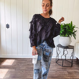Black long sleeved blouse with lace and eyelet ruffle detail throughout.