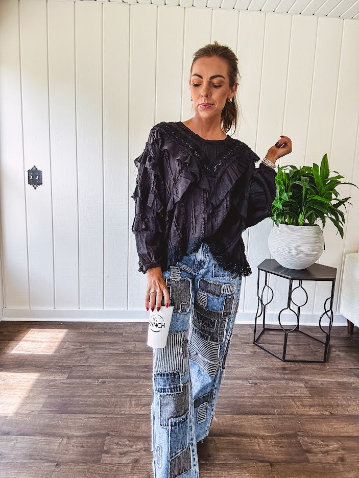 Black long sleeved blouse with lace and eyelet ruffle detail throughout.