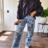 Medium wash denim wide leg pants with washed black, black and white stripe and denim patchwork detail throughout.