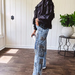 Medium wash denim wide leg pants with washed black, black and white stripe and denim patchwork detail throughout.