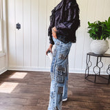 Medium wash denim wide leg pants with washed black, black and white stripe and denim patchwork detail throughout.