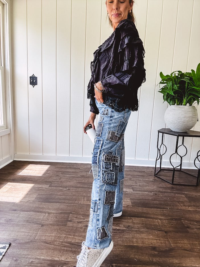 Medium wash denim wide leg pants with washed black, black and white stripe and denim patchwork detail throughout.
