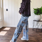 Medium wash denim wide leg pants with washed black, black and white stripe and denim patchwork detail throughout.