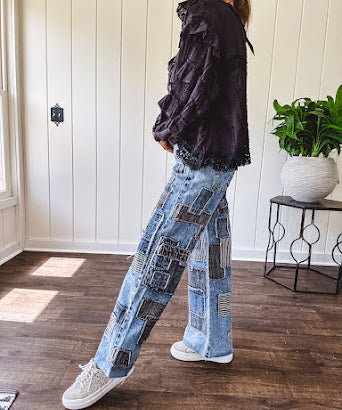 Medium wash denim wide leg pants with washed black, black and white stripe and denim patchwork detail throughout.