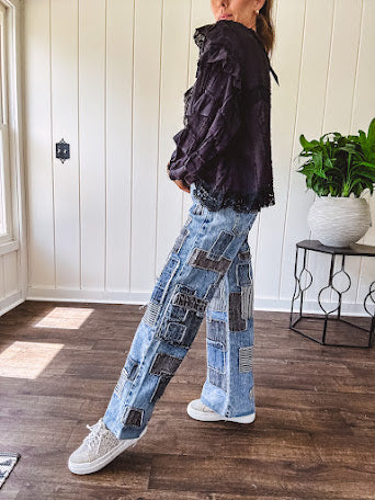 Medium wash denim wide leg pants with washed black, black and white stripe and denim patchwork detail throughout.