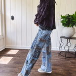 Medium wash denim wide leg pants with washed black, black and white stripe and denim patchwork detail throughout.