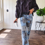 Medium wash denim wide leg pants with washed black, black and white stripe and denim patchwork detail throughout.