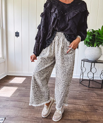 Light wash leopard print elastic waist wide leg pants with frayed hem.
