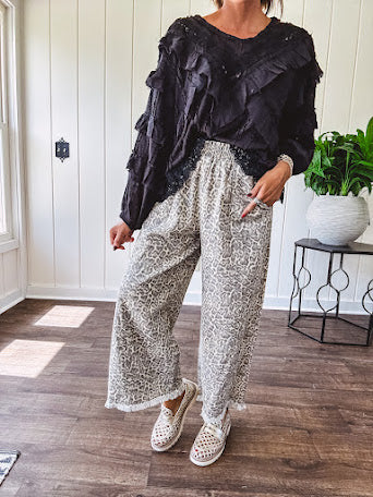 Light wash leopard print elastic waist wide leg pants with frayed hem.
