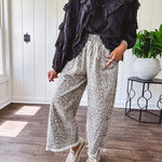 Light wash leopard print elastic waist wide leg pants with frayed hem.
