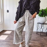 Light wash leopard print elastic waist wide leg pants with frayed hem.