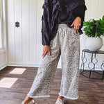 Light wash leopard print elastic waist wide leg pants with frayed hem.