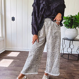 Light wash leopard print elastic waist wide leg pants with frayed hem.