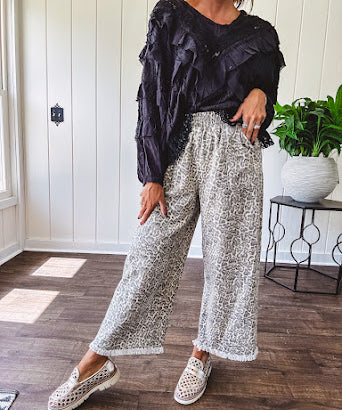 Light wash leopard print elastic waist wide leg pants with frayed hem.