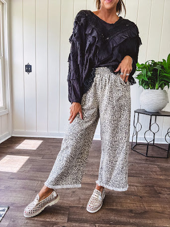 Light wash leopard print elastic waist wide leg pants with frayed hem.