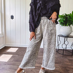 Light wash leopard print elastic waist wide leg pants with frayed hem.