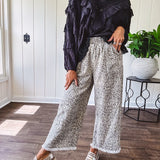 Light wash leopard print elastic waist wide leg pants with frayed hem.