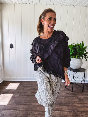Light wash leopard print elastic waist wide leg pants with frayed hem.