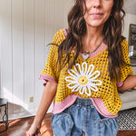 Open weave crochet sweater with 3/4 sleeves and large contrasting crochet flower on the front and contrasting trim. Oversized. Available in multiple colors.