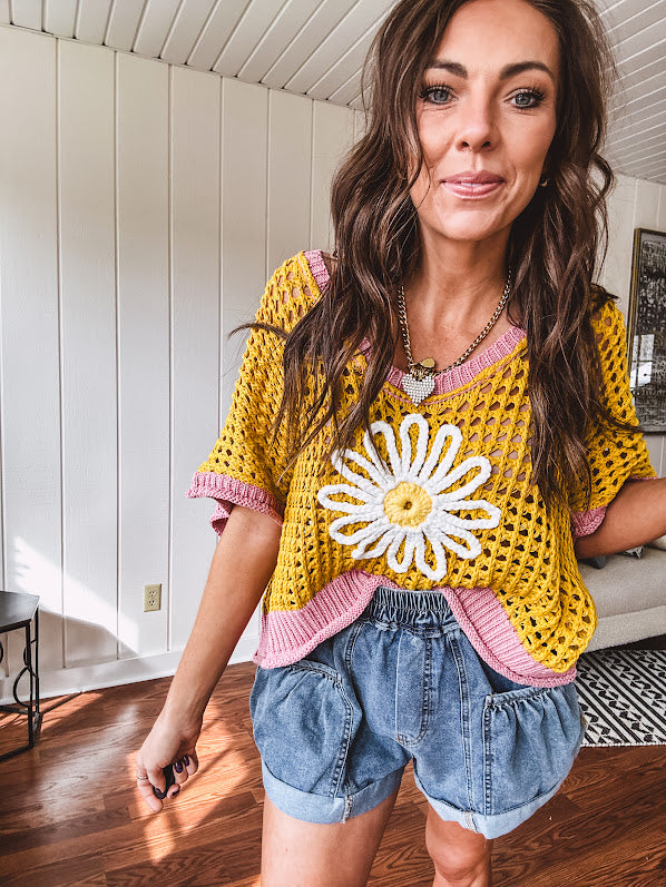Open weave crochet sweater with 3/4 sleeves and large contrasting crochet flower on the front and contrasting trim. Oversized. Available in multiple colors.