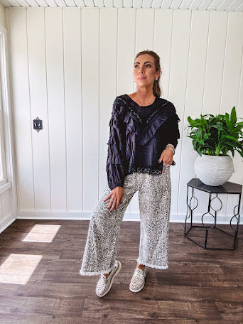 Light wash leopard print elastic waist wide leg pants with frayed hem.