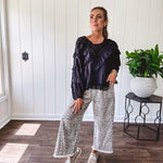 Light wash leopard print elastic waist wide leg pants with frayed hem.